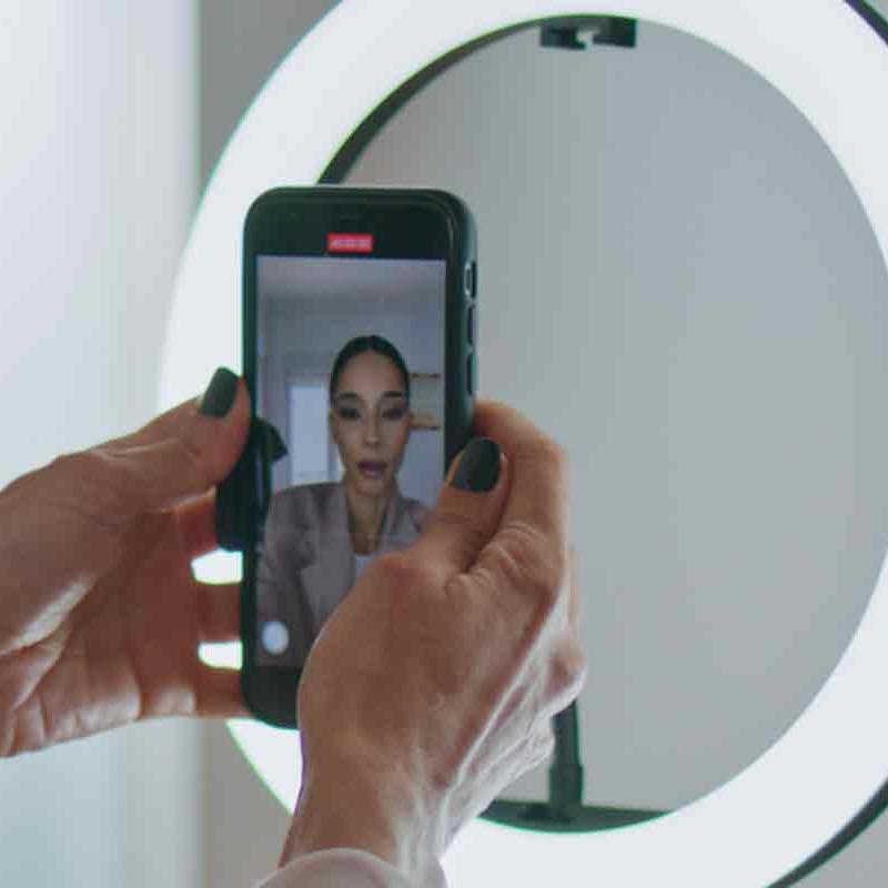 woman content creator with ring light and phone on tripod